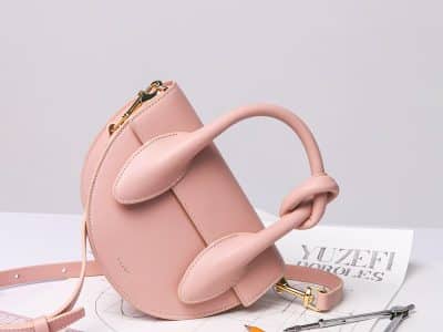 brown leather handbag on white ruled paper